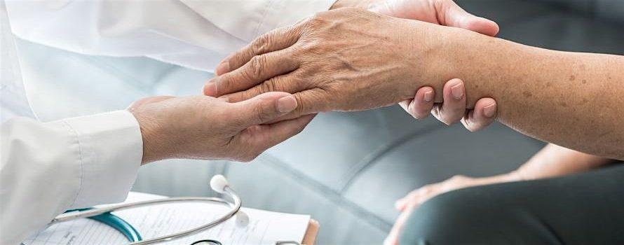 Healthcare professional gently holds an elderly patient’s hand, with a stethoscope and clipboard nearby.