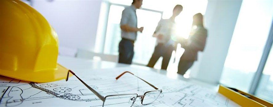 Yellow hard hat and glasses on architectural blueprints on a desk, with three people talking in the background in a bright office.